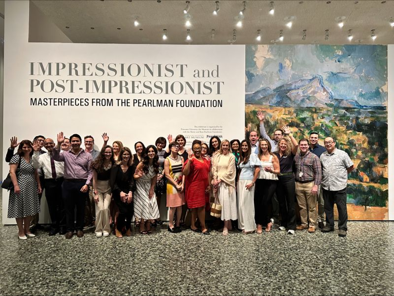 Group of roughly 30 physicians smiling in front of art exhibit titled Impressionist and post-Impressionist masterpieces from the Pearlman Foundation