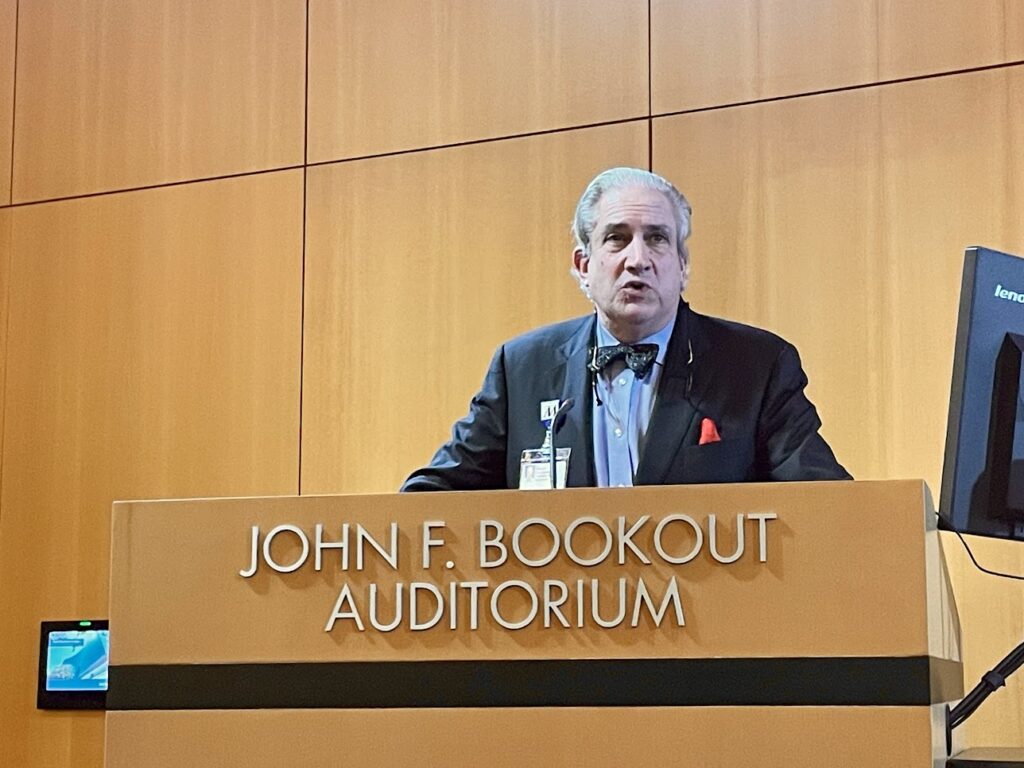 Dr. Robert Jackson in front of a podium that reads John F. Bookout Auditorium